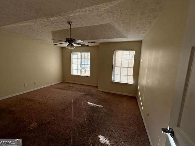 carpeted spare room with vaulted ceiling, ceiling fan, and a textured ceiling