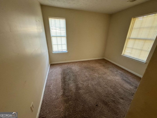 carpeted spare room with a textured ceiling