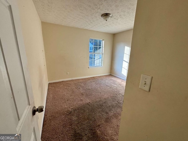 spare room featuring a textured ceiling and carpet floors