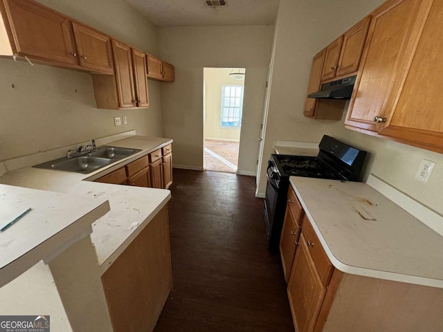 kitchen with black gas range, dark hardwood / wood-style floors, kitchen peninsula, and sink