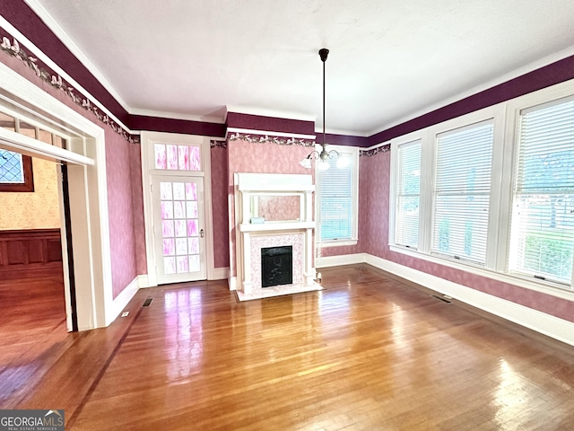 unfurnished living room featuring a notable chandelier and hardwood / wood-style floors