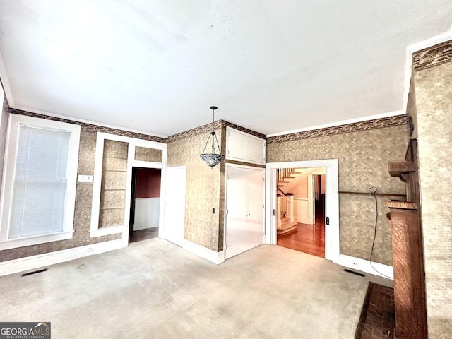 interior space featuring carpet flooring and crown molding