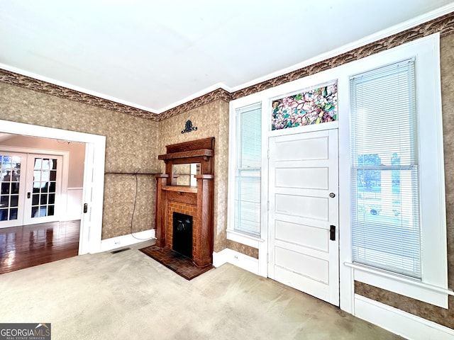 living room featuring crown molding, french doors, and carpet flooring