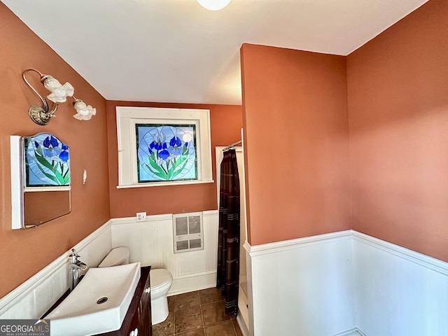 bathroom featuring tile patterned floors, vanity, toilet, walk in shower, and heating unit