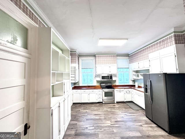 kitchen with white cabinets, crown molding, stainless steel appliances, and light hardwood / wood-style flooring