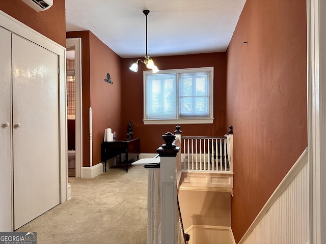 interior space featuring light colored carpet, a notable chandelier, and a wall unit AC