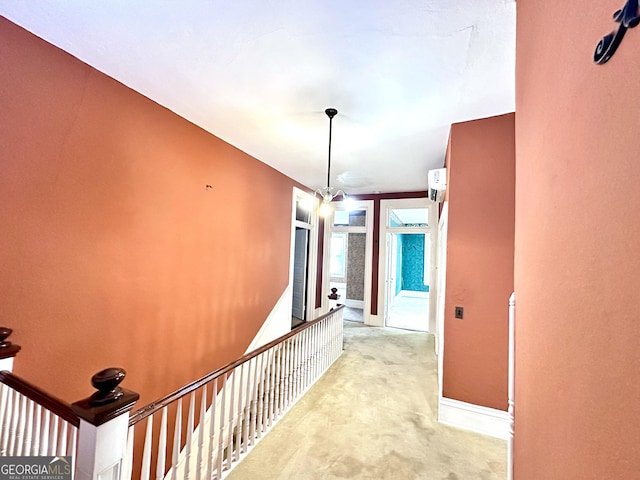 corridor featuring light carpet and a notable chandelier