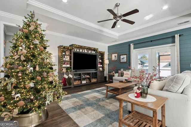 living room with ornamental molding, ceiling fan, and dark wood-type flooring