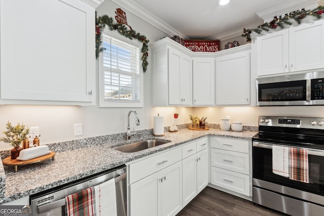 kitchen with white cabinets, sink, ornamental molding, appliances with stainless steel finishes, and dark hardwood / wood-style flooring