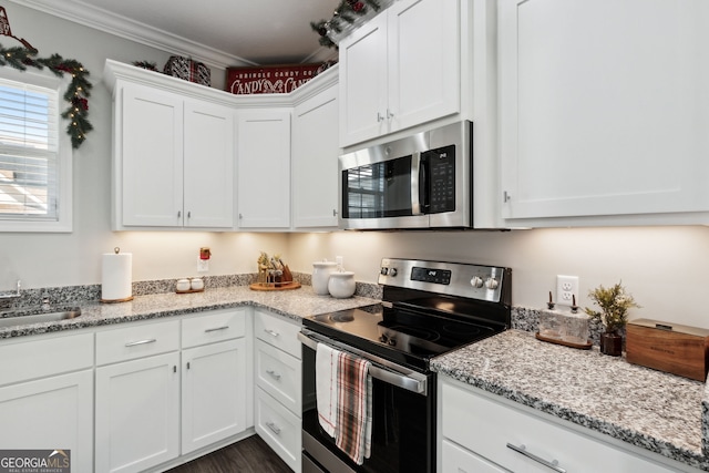 kitchen with light stone counters, sink, white cabinets, and appliances with stainless steel finishes