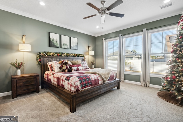 carpeted bedroom featuring a textured ceiling, ceiling fan, and crown molding