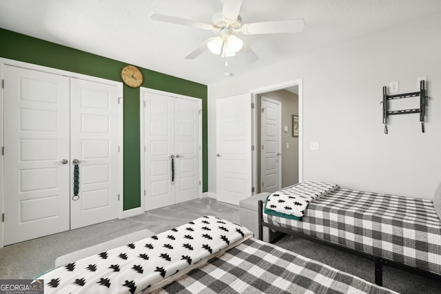 bedroom featuring a textured ceiling, two closets, and ceiling fan