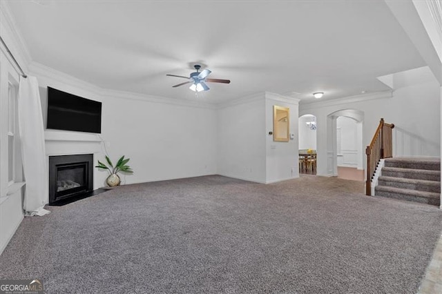 unfurnished living room featuring carpet flooring, ceiling fan, and ornamental molding