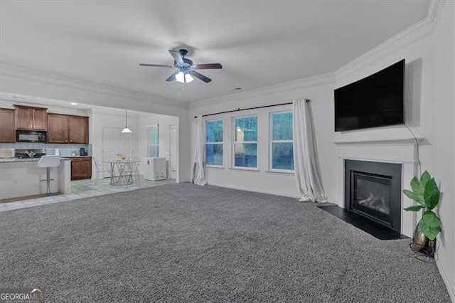 unfurnished living room featuring dark carpet, ceiling fan, and crown molding