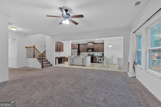 unfurnished living room featuring ceiling fan, crown molding, and light carpet