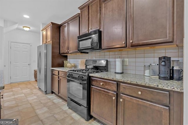 kitchen with light stone countertops, dark brown cabinets, tasteful backsplash, and black appliances