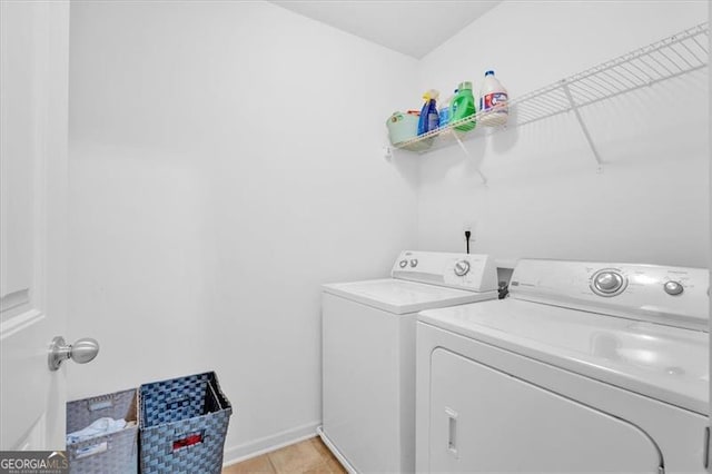 laundry area with light tile patterned floors and washing machine and clothes dryer