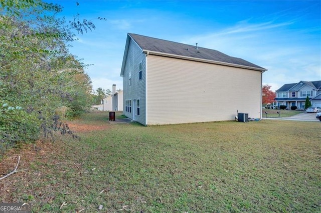 view of property exterior with central AC unit and a yard