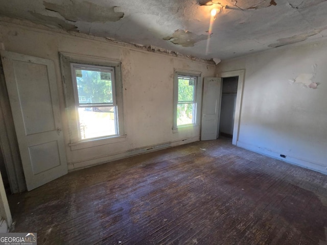 spare room with dark hardwood / wood-style flooring and plenty of natural light