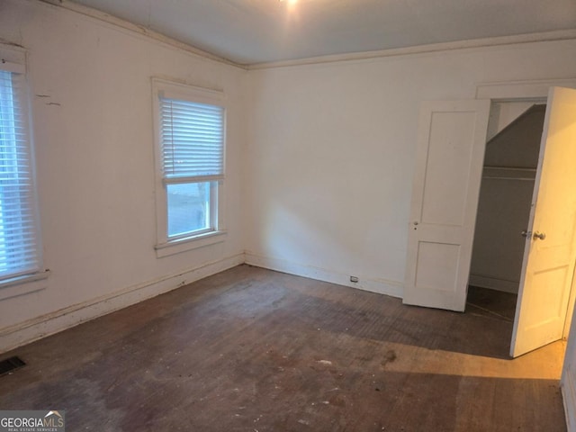 unfurnished bedroom with a closet and dark wood-type flooring