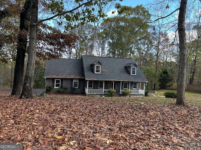 cape cod house featuring covered porch