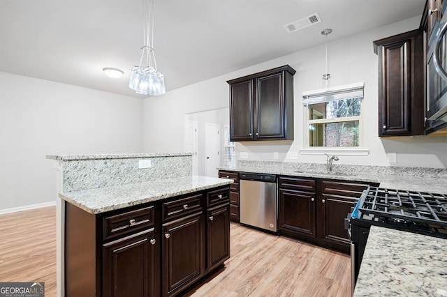 kitchen featuring sink, hanging light fixtures, stainless steel appliances, light hardwood / wood-style floors, and dark brown cabinets