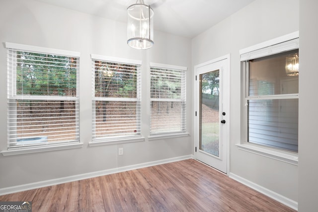 unfurnished sunroom featuring a wealth of natural light and a chandelier