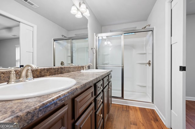 bathroom featuring hardwood / wood-style floors, vanity, and walk in shower