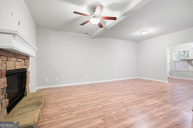 unfurnished living room with a stone fireplace, ceiling fan, and light wood-type flooring