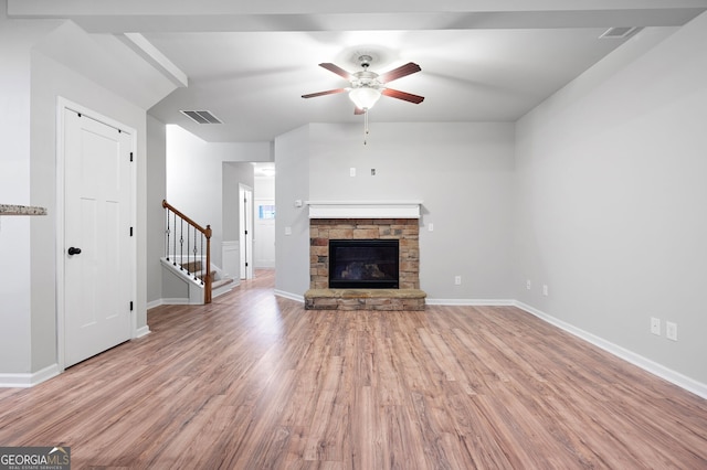 unfurnished living room featuring a fireplace, light hardwood / wood-style floors, and ceiling fan