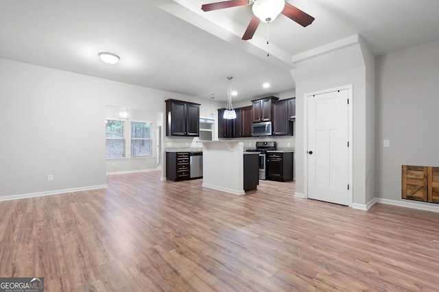 kitchen featuring light hardwood / wood-style floors, appliances with stainless steel finishes, decorative light fixtures, a kitchen island, and dark brown cabinetry