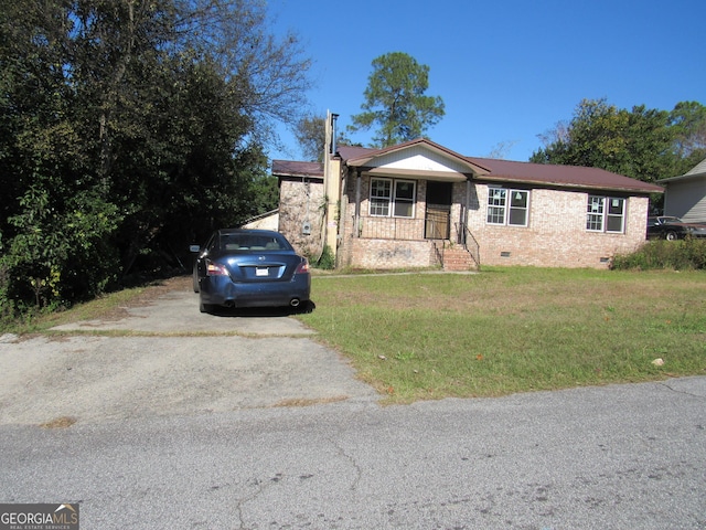 ranch-style house featuring covered porch and a front yard