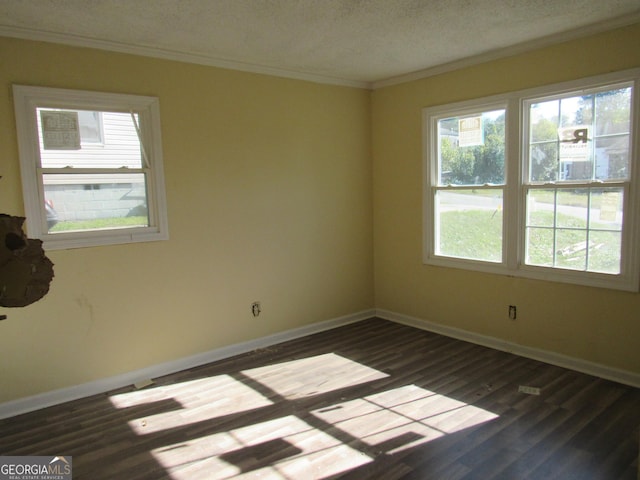 empty room featuring dark wood-type flooring, a textured ceiling, and ornamental molding