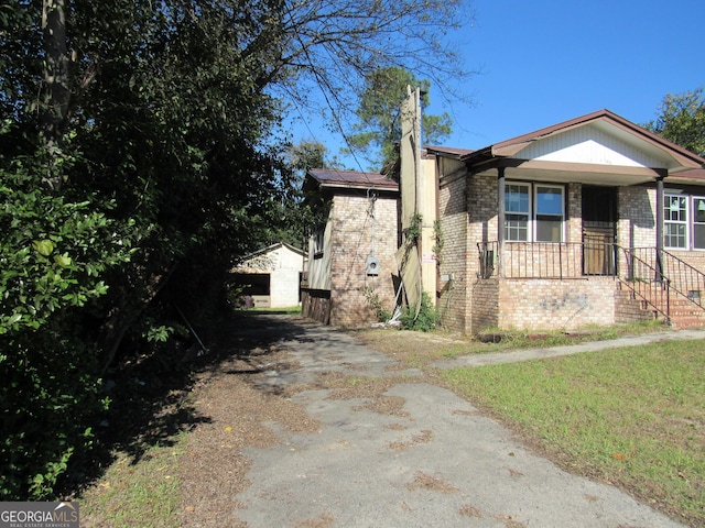 view of front of home featuring covered porch and a front lawn