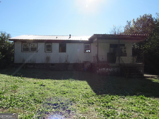 rear view of property with a yard