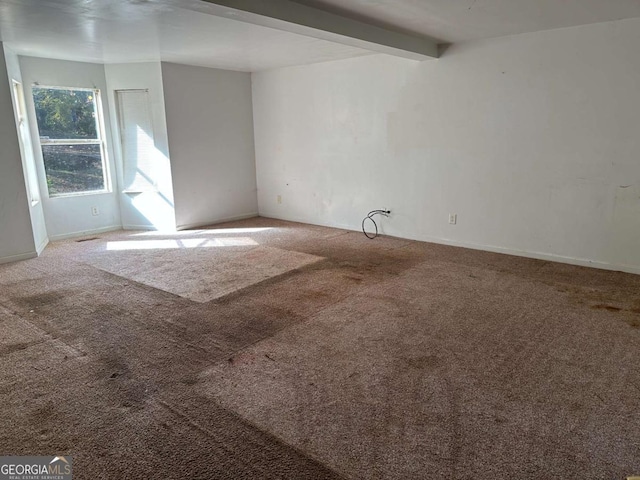 carpeted spare room featuring beam ceiling