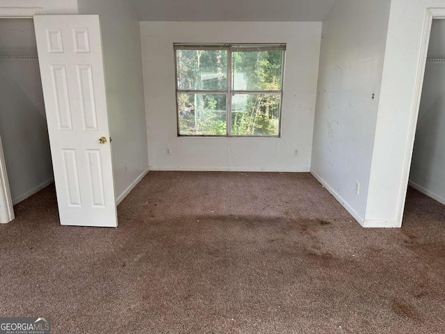 unfurnished bedroom featuring dark colored carpet