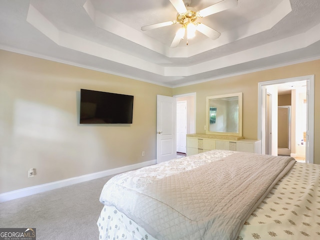 carpeted bedroom with a tray ceiling, ceiling fan, and ornamental molding