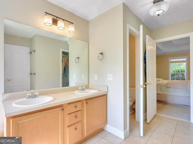 bathroom with tile patterned flooring, vanity, toilet, and a textured ceiling