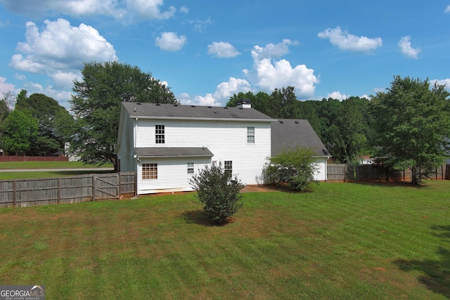 rear view of house featuring a lawn