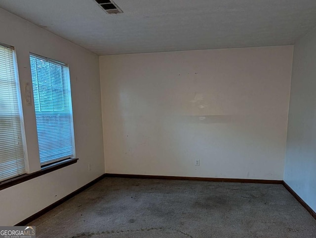 carpeted spare room with a textured ceiling