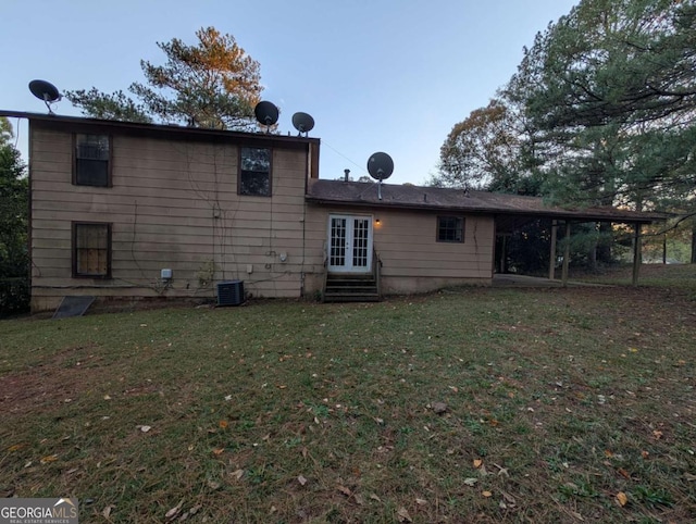 back of house featuring a lawn and central AC unit