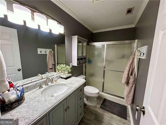 bathroom featuring walk in shower, a textured ceiling, toilet, vanity, and ornamental molding