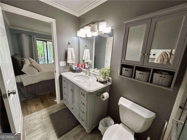 bathroom featuring hardwood / wood-style flooring, vanity, toilet, and crown molding