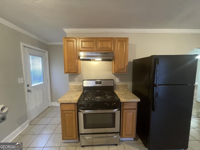 kitchen featuring a textured ceiling, black refrigerator, stainless steel gas stove, light tile patterned floors, and crown molding