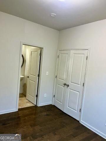 unfurnished bedroom featuring dark hardwood / wood-style flooring and a closet