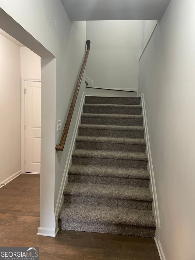 staircase with hardwood / wood-style flooring