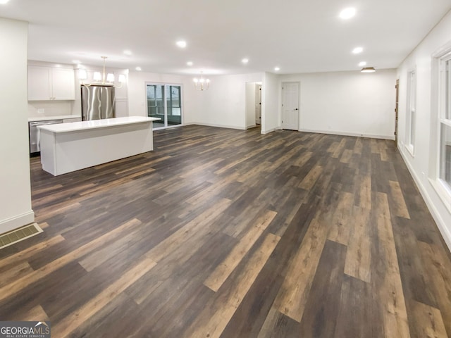 unfurnished living room featuring dark hardwood / wood-style floors and a chandelier