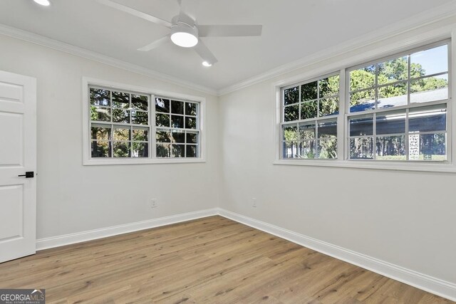 empty room featuring ceiling fan, light hardwood / wood-style flooring, crown molding, and vaulted ceiling