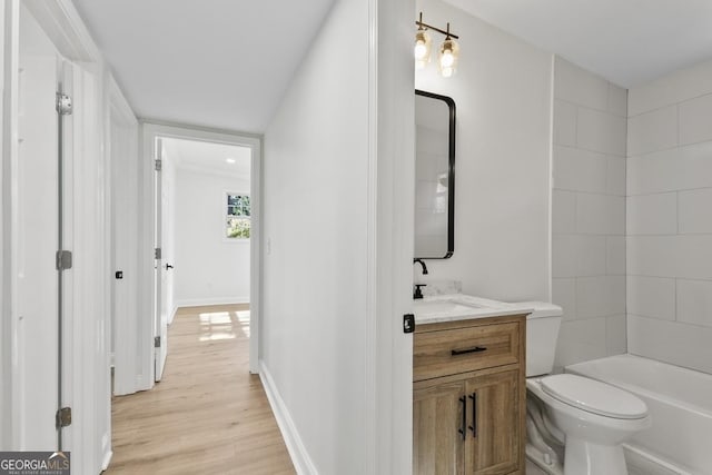 full bathroom featuring hardwood / wood-style floors, vanity, toilet, and tub / shower combination